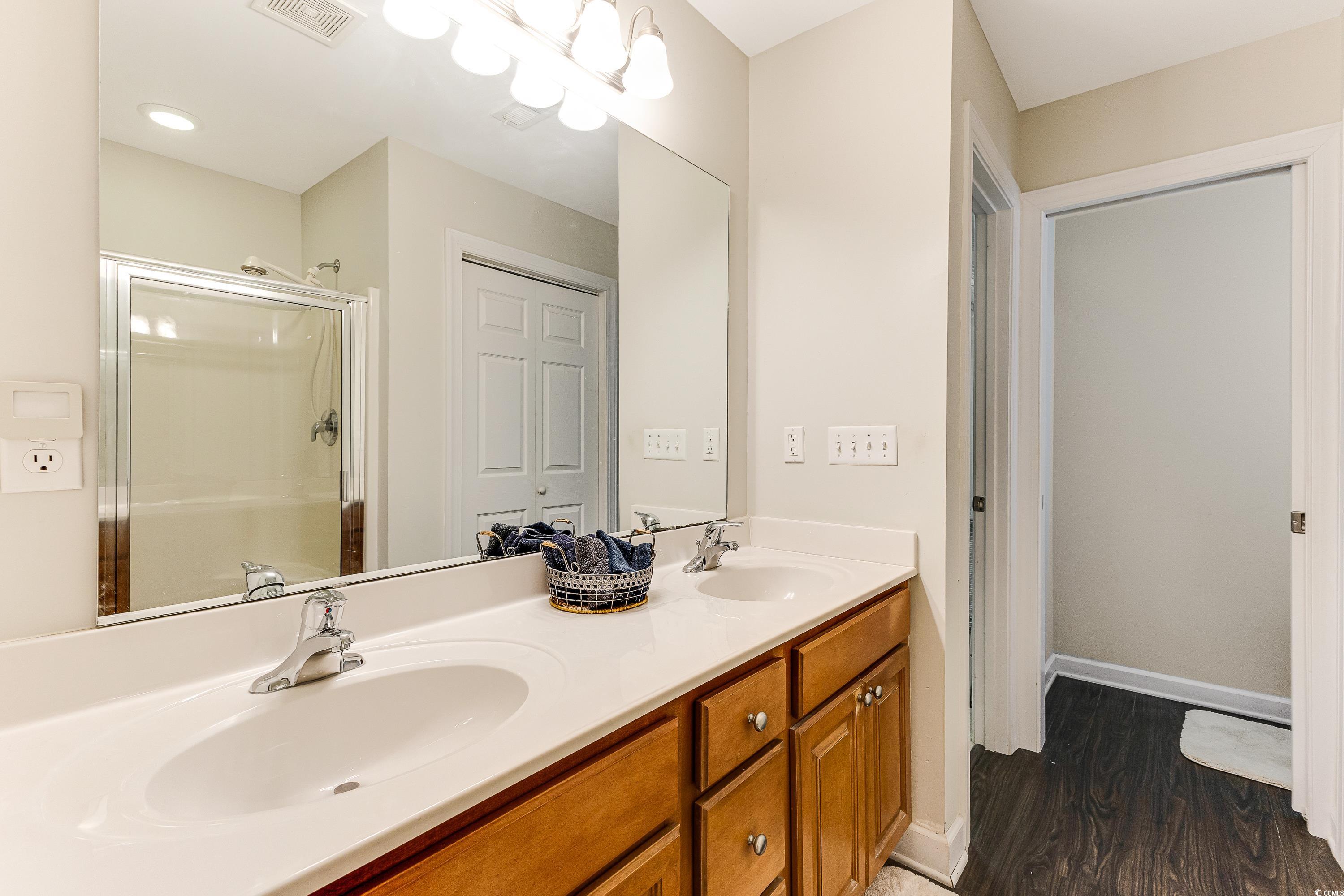 101 Cedar Tree Lane Southwest Calabash, NC 28467 - Photo 21 of 40 Full bath featuring double vanity, a shower stall, and wood finished floors