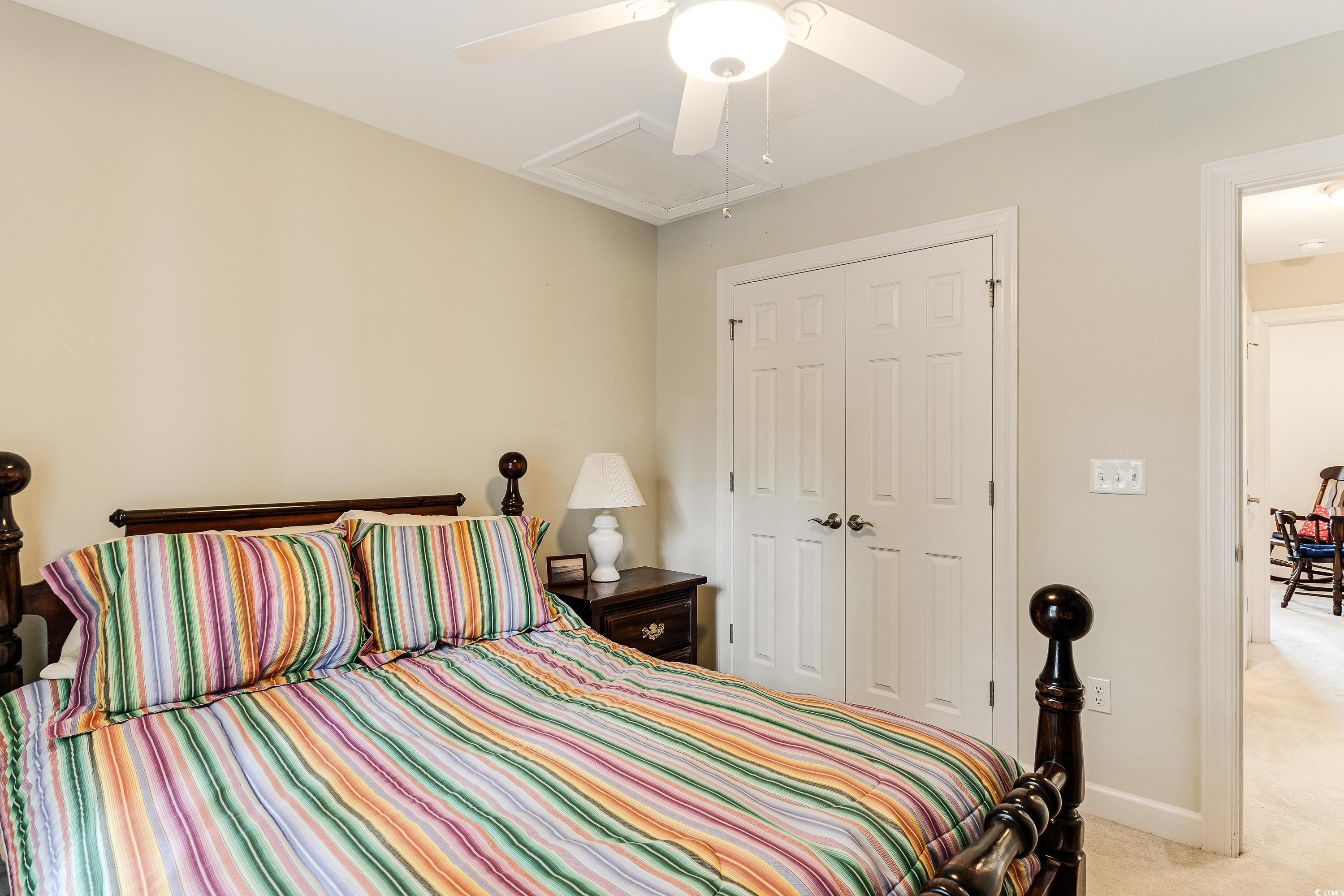 101 Cedar Tree Lane Southwest Calabash, NC 28467 - Photo 29 of 40 Bedroom with attic access, light carpet, a closet, and a ceiling fan