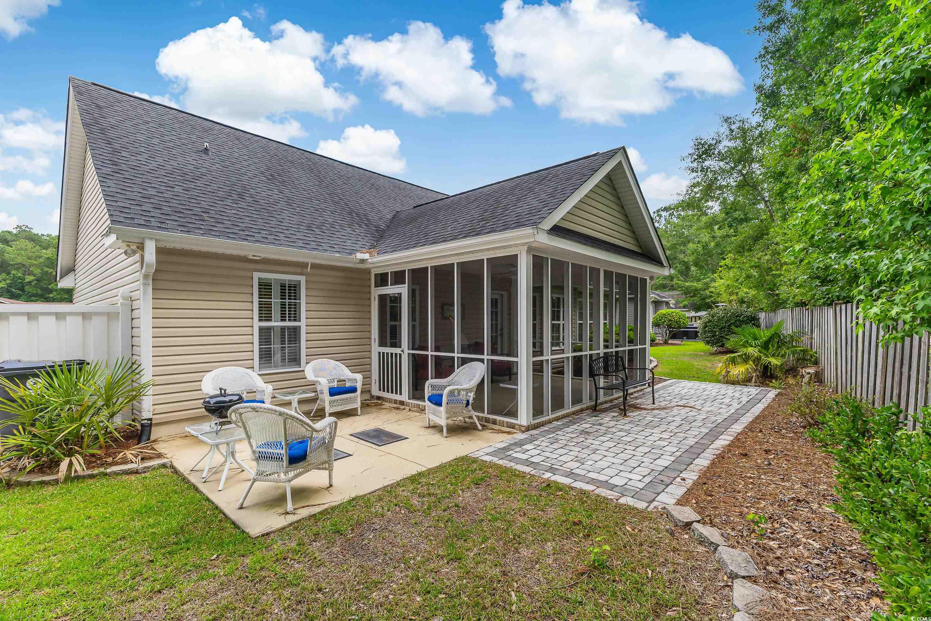 101 Cedar Tree Lane Southwest Calabash, NC 28467 - Photo 34 of 40 Back of house with a sunroom, a patio, a shingled roof, and a fenced backyard
