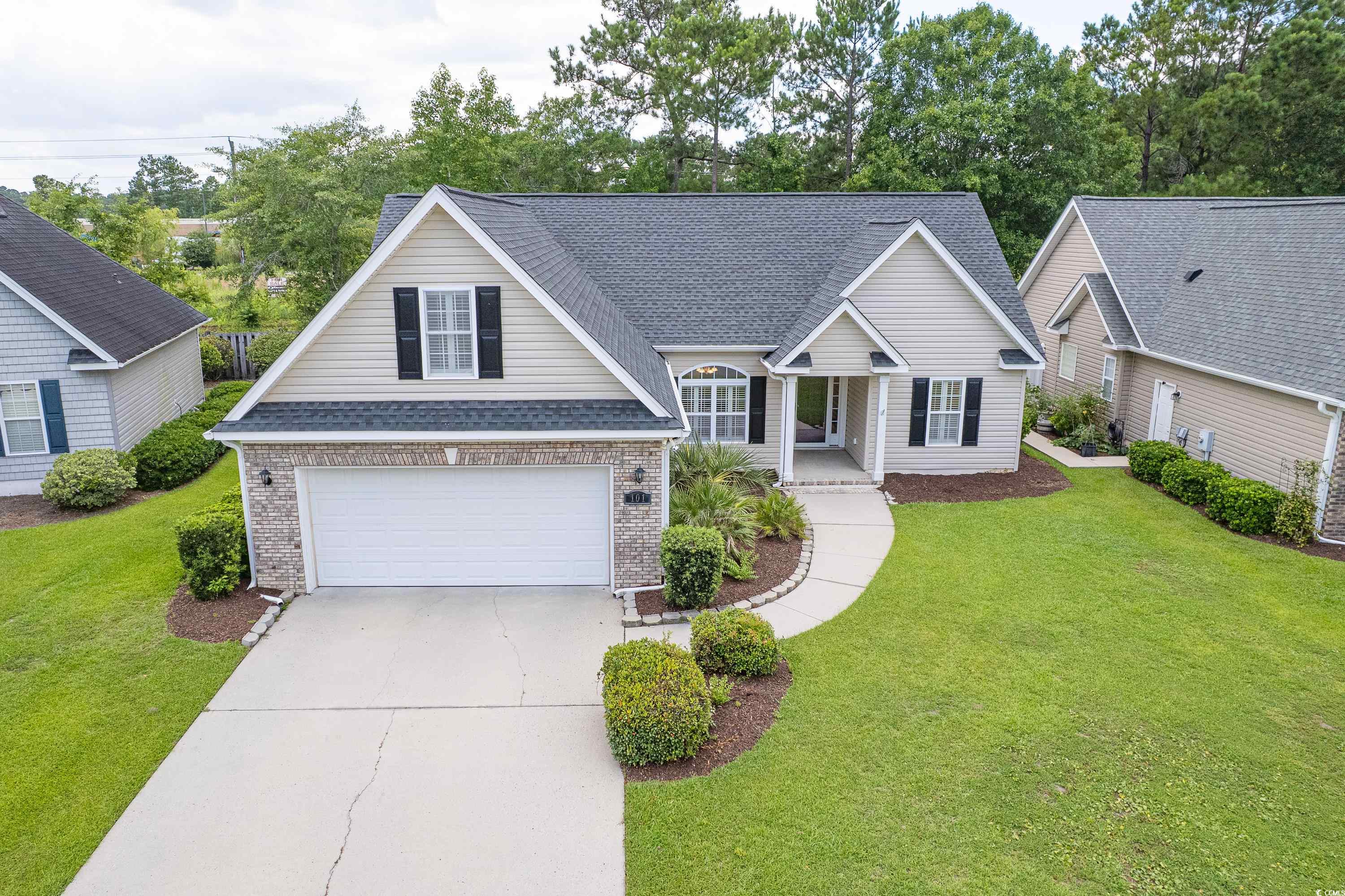101 Cedar Tree Lane Southwest Calabash, NC 28467 - Photo 35 of 40 Traditional-style house featuring concrete driveway, roof with shingles, a front lawn, and brick siding