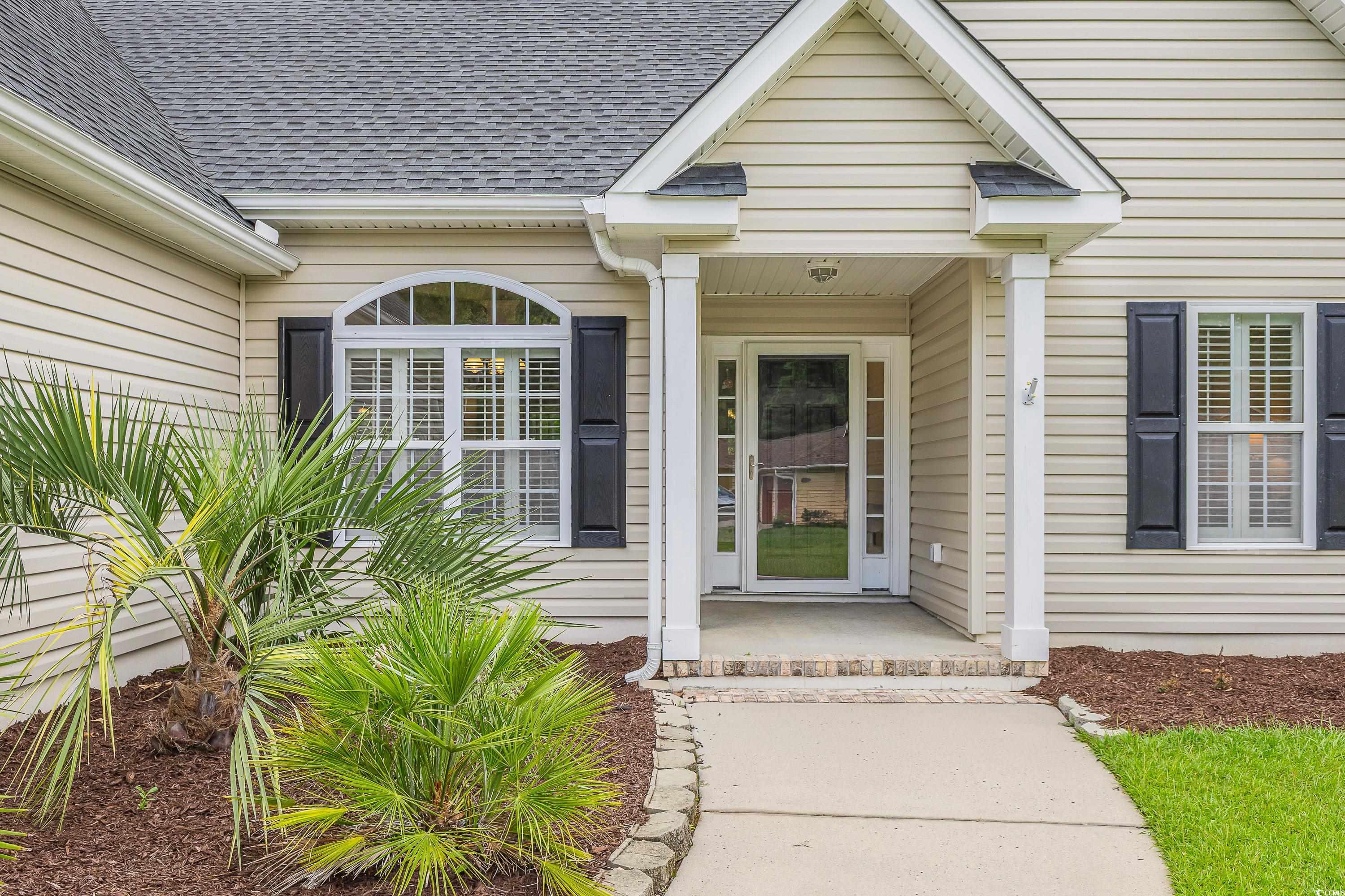 101 Cedar Tree Lane Southwest Calabash, NC 28467 - Photo 4 of 40 Doorway to property with roof with shingles and a porch