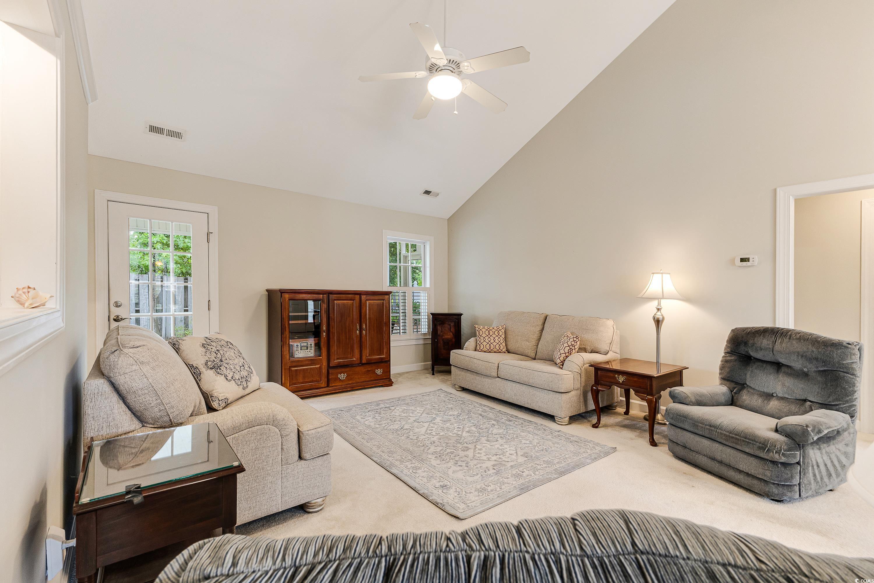 101 Cedar Tree Lane Southwest Calabash, NC 28467 - Photo 8 of 40 Carpeted living room with high vaulted ceiling, healthy amount of natural light, and ceiling fan