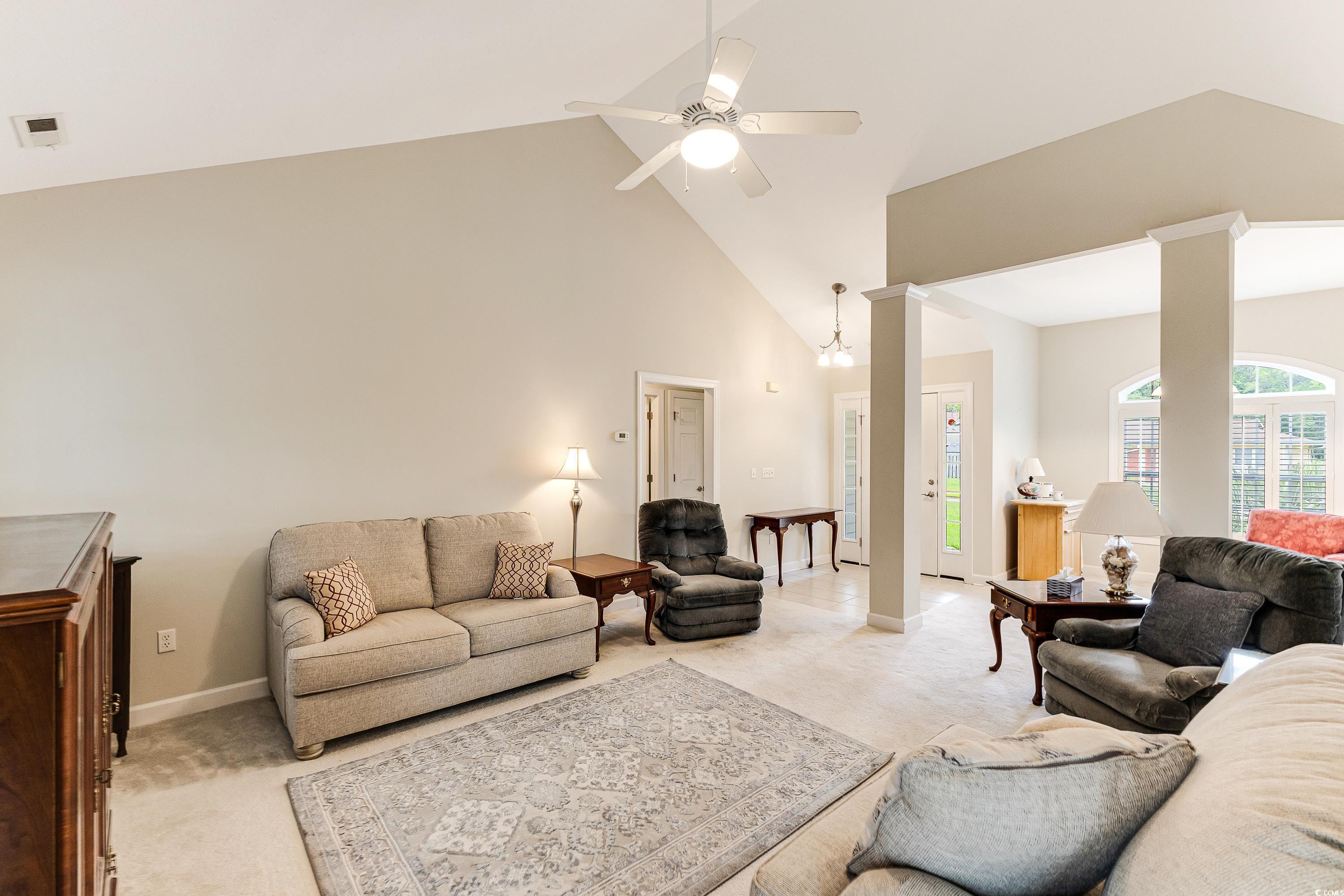 101 Cedar Tree Lane Southwest Calabash, NC 28467 - Photo 9 of 40 Living room featuring light carpet, high vaulted ceiling, and ceiling fan