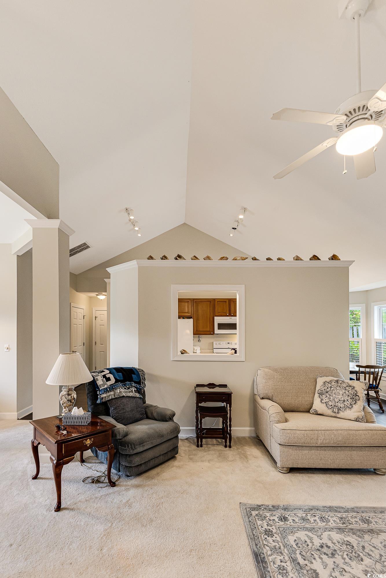 101 Cedar Tree Lane Southwest Calabash, NC 28467 - Photo 10 of 40 Living area featuring light colored carpet, lofted ceiling, and ceiling fan