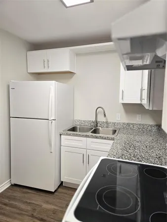 a kitchen with a sink a refrigerator and cabinets