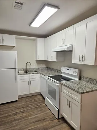 a kitchen with granite countertop white cabinets and white appliances