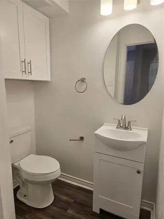 a bathroom with a toilet a sink and mirror