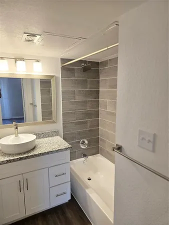 a bathroom with a double vanity sink mirror and bathtub
