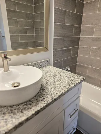 a bathroom with a granite countertop bathtub and sink