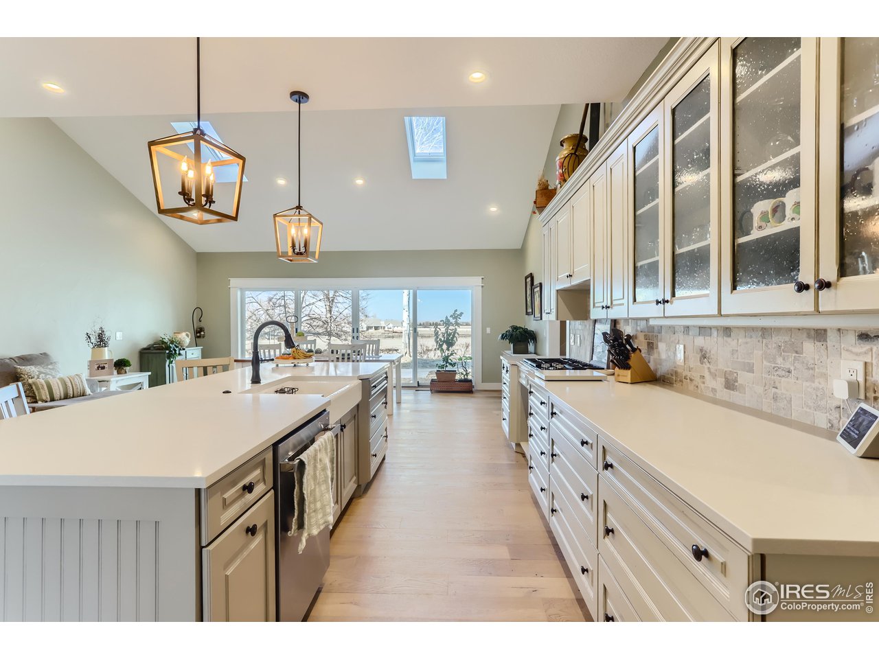 8435 Brittany Place Niwot, CO 80503 - Photo 14 of 40 a large kitchen with kitchen island a sink a stove and wooden floors