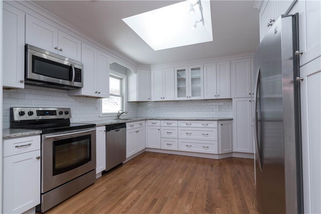 18 Ritch Drive Ridgefield, CT 06877 - Photo 1 of 1 a kitchen with stainless steel appliances white cabinets a stove a sink and a microwave