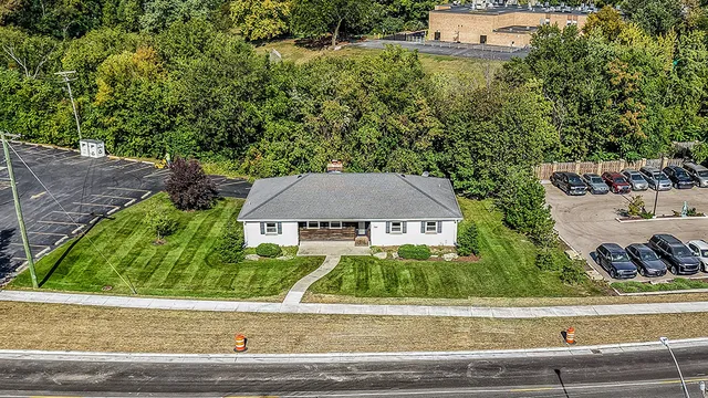 front view of house with a small yard and large trees