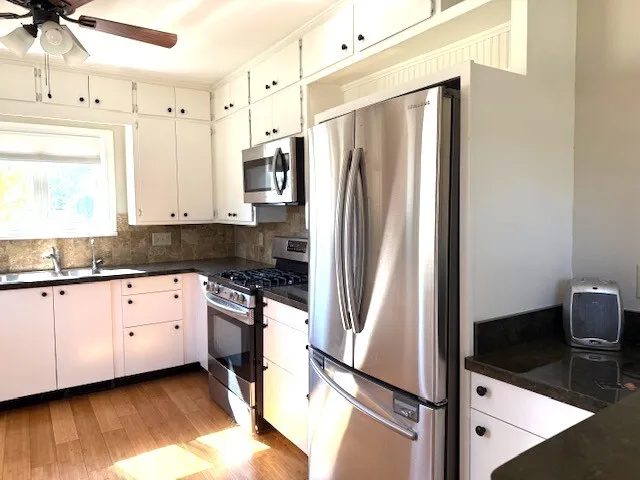 a kitchen with granite countertop a refrigerator and a sink