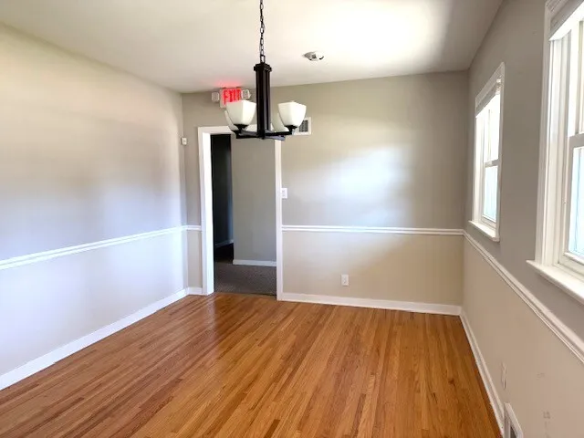 a view of empty room with wooden floor and window