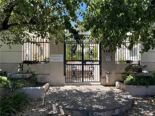 a front view of a house with a tree