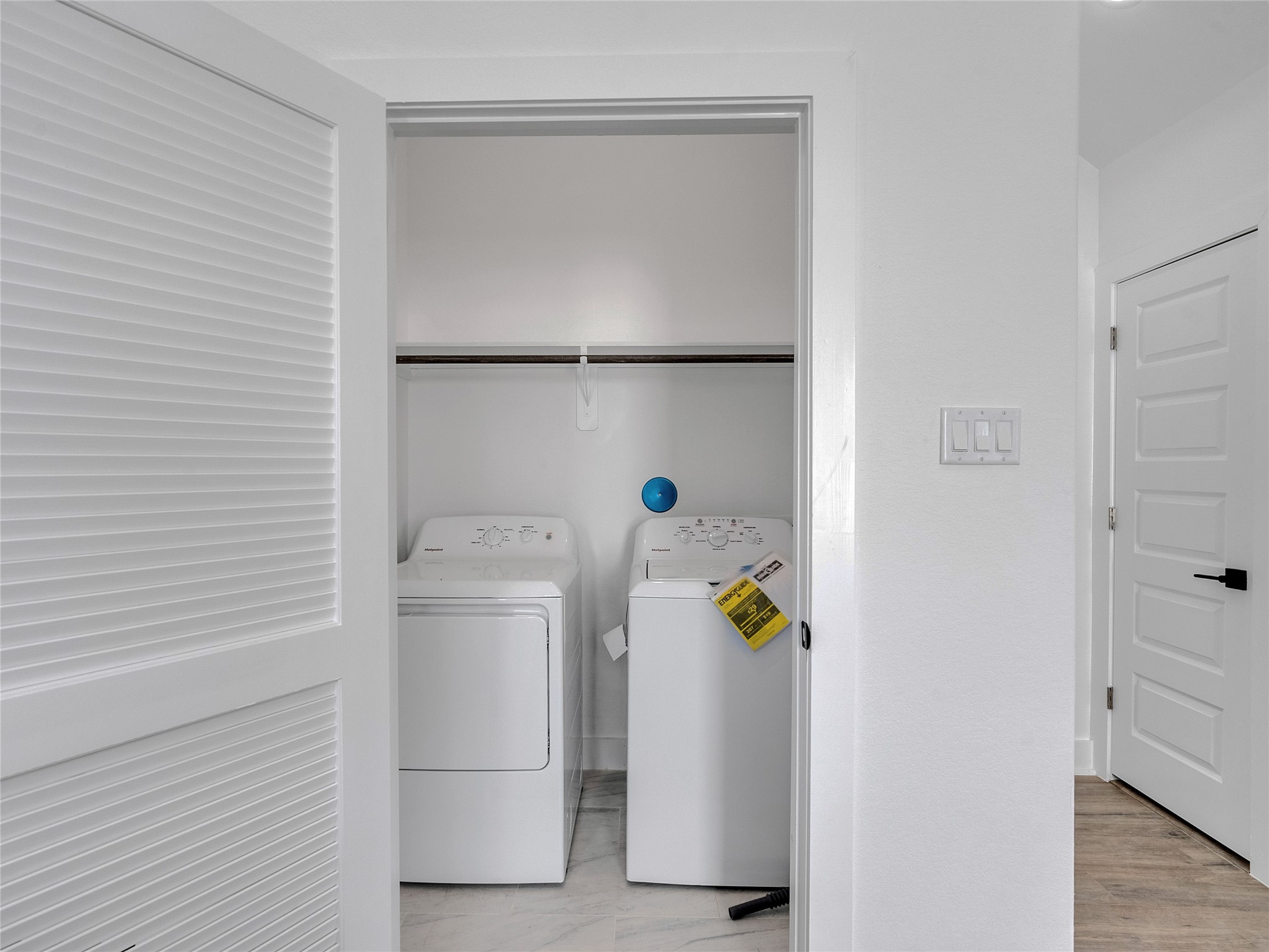 5126 Clover Street, Unit A/B Houston, TX 77033 - Photo 14 of 29 Compact laundry area with a washer and dryer, featuring a sliding louvered door and adjacent to a hallway. Ideal for efficient use of space.