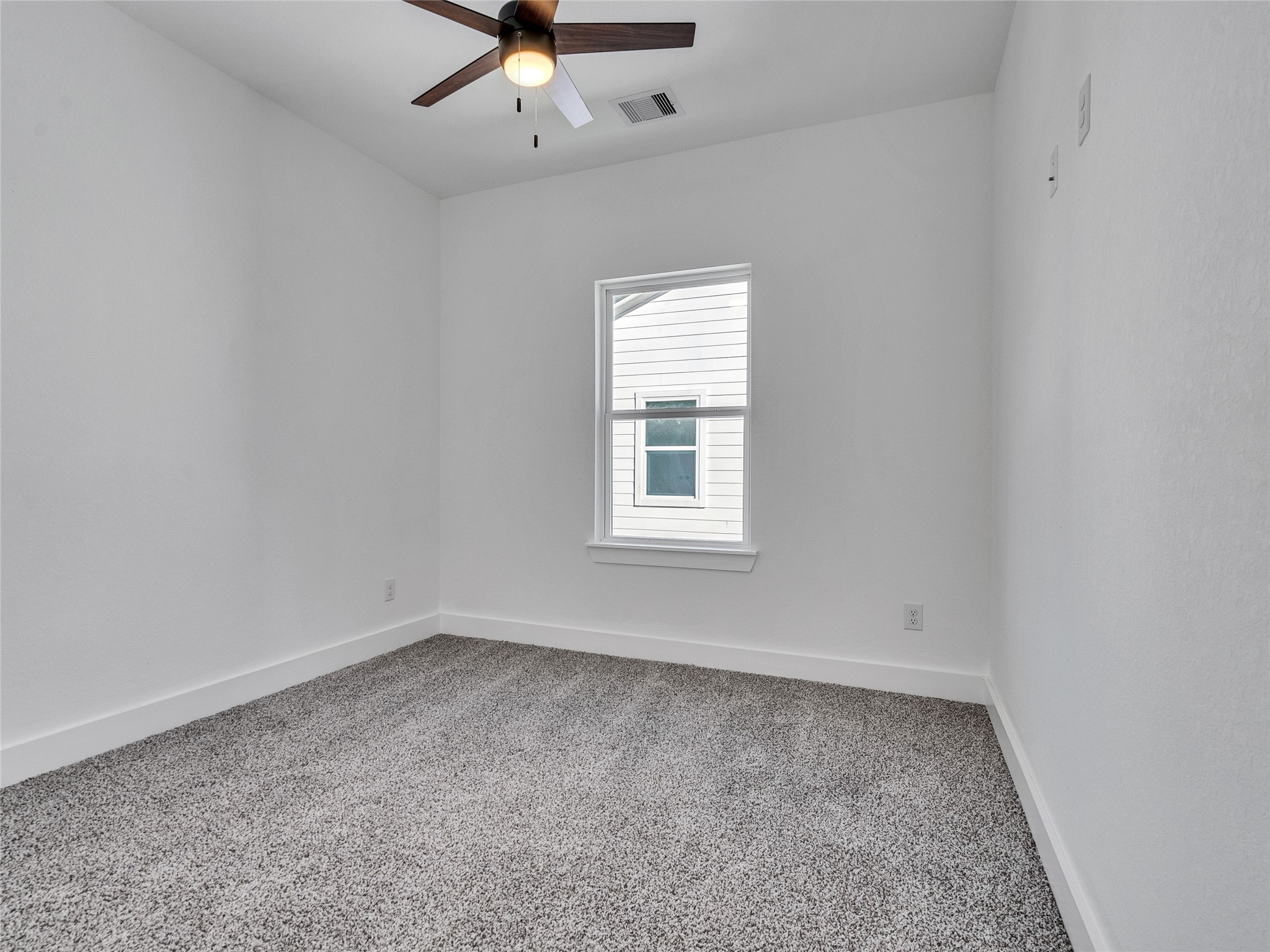 5126 Clover Street, Unit A/B Houston, TX 77033 - Photo 18 of 29 This is a bright, carpeted room with neutral walls, featuring a ceiling fan and a single window, ideal for a bedroom or office space.