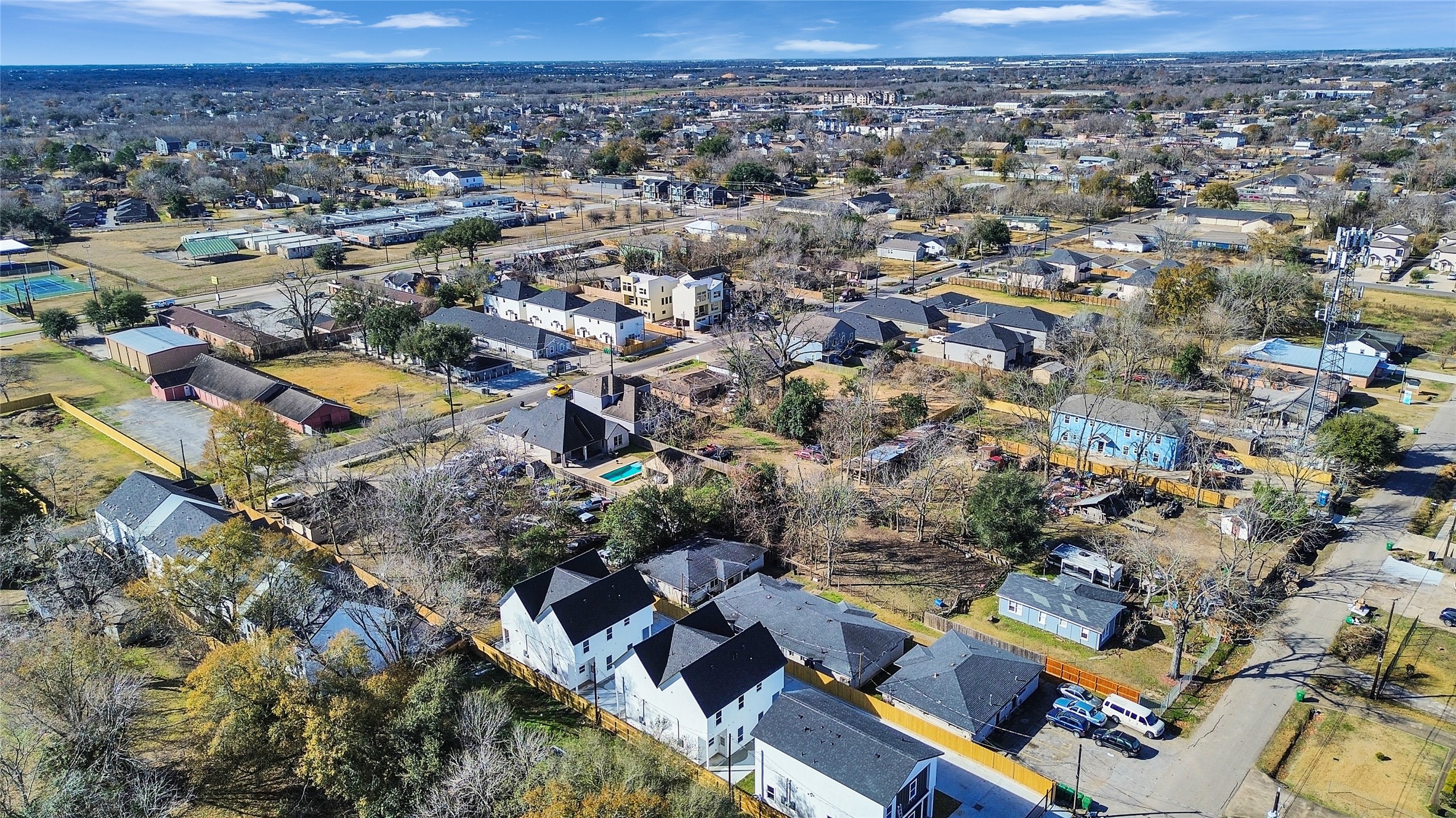 5126 Clover Street, Unit A/B Houston, TX 77033 - Photo 2 of 29 This aerial photo showcases a residential neighborhood with a mix of homes, some featuring spacious yards and tree-lined streets. There's a visible pool and a variety of housing styles. The area appears well-established with nearby amenities and open spaces, ideal for family living.