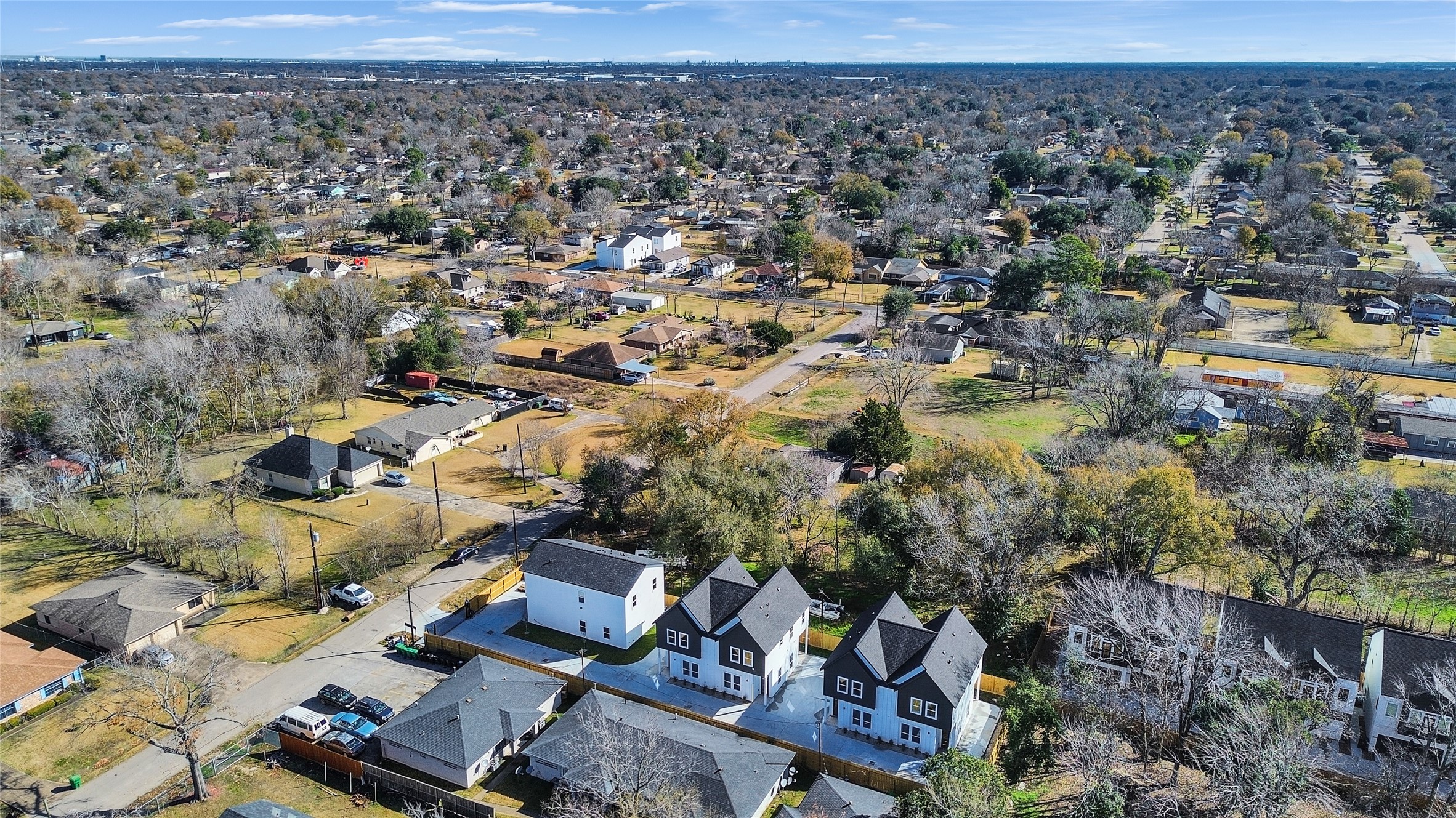 5126 Clover Street, Unit A/B Houston, TX 77033 - Photo 3 of 29 This aerial view showcases a suburban neighborhood with a mix of modern and traditional homes, surrounded by trees and open spaces. The area appears spacious and well-connected with visible roads, providing a peaceful and accessible living environment.