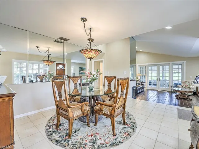a view of a dining room and livingroom with furniture wooden floor a chandelier