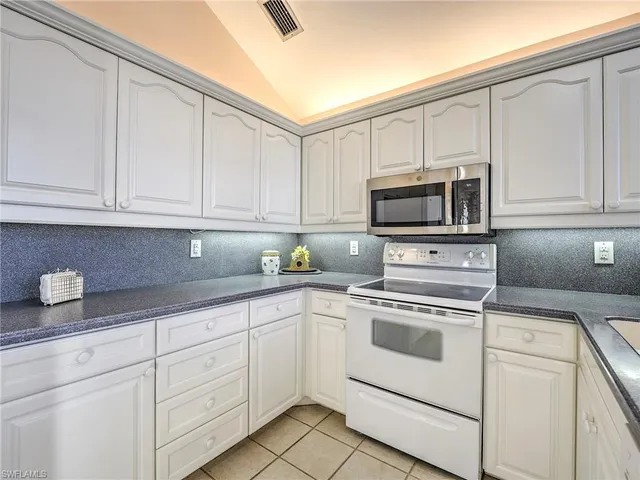 a kitchen with white cabinets stainless steel appliances and sink