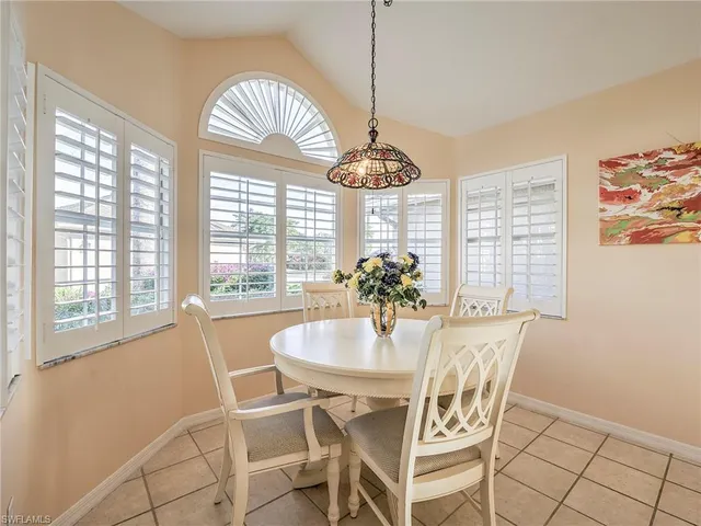 a dining room with furniture a chandelier and wooden floor