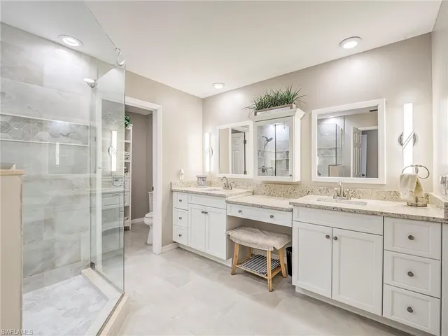 a spacious bathroom with a granite countertop sink mirror and shower