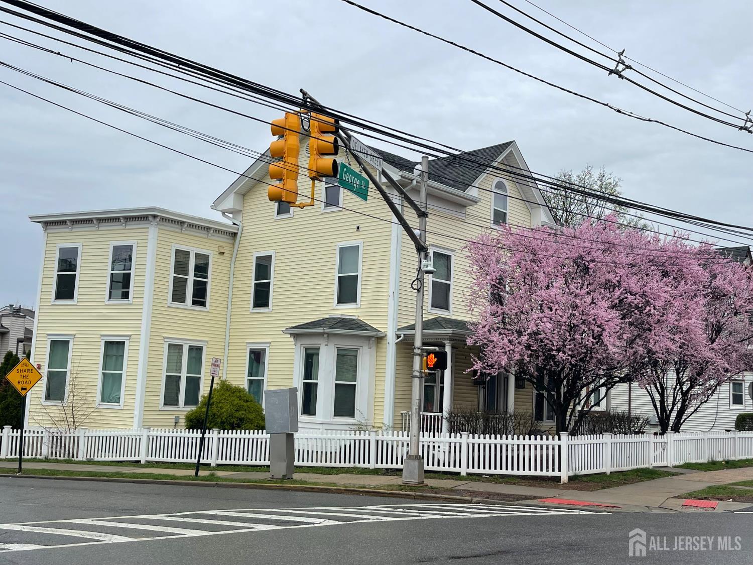 a view of a white house with a street