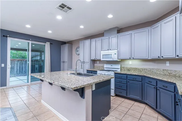 a kitchen with kitchen island granite countertop a sink window and cabinets