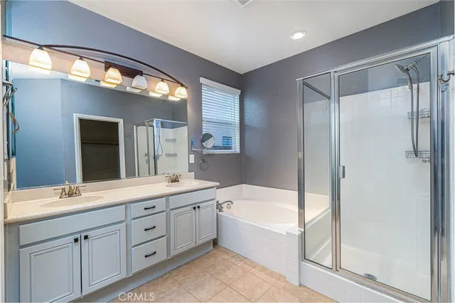 a spacious bathroom with a double vanity sink a mirror and a bathtub