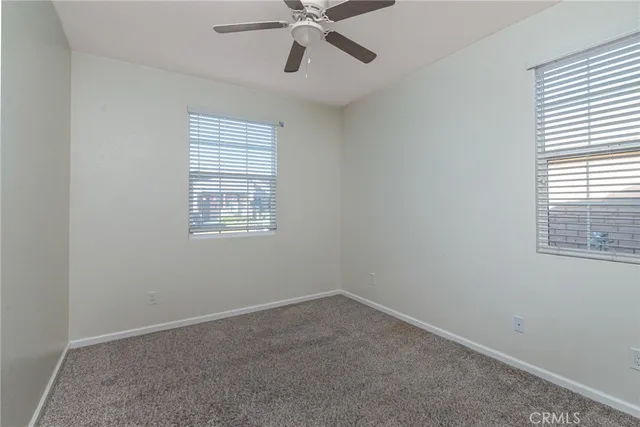 an empty room with a window and a fan
