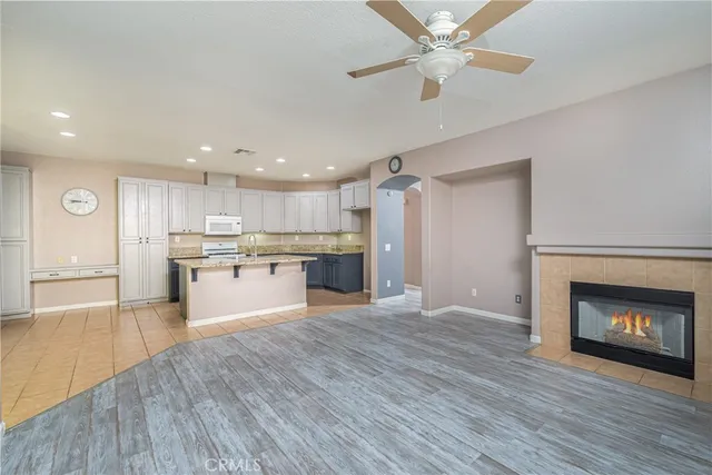 a large kitchen with a fireplace and wooden floor