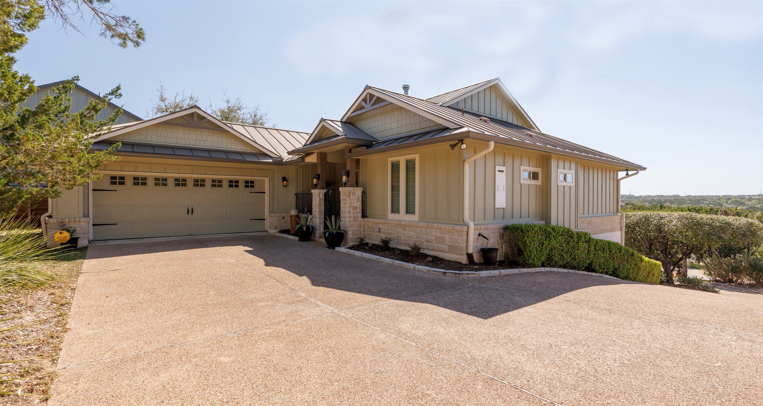 261 Barber Drive Wimberley, TX 78676 - Photo 1 of 37 Craftsman house with a standing seam roof, driveway, an attached garage, and board and batten siding