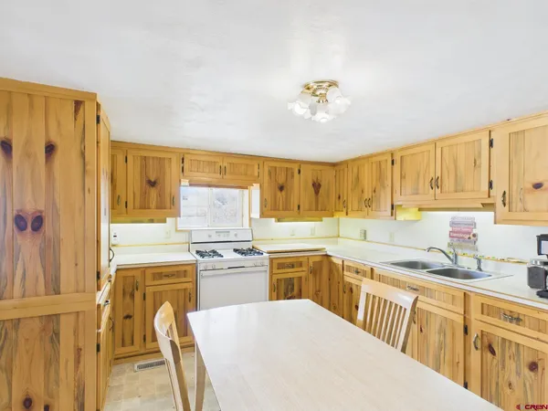 a kitchen with a stove a sink and a refrigerator