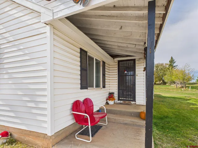 a view of a porch with a table and chairs and potted plants