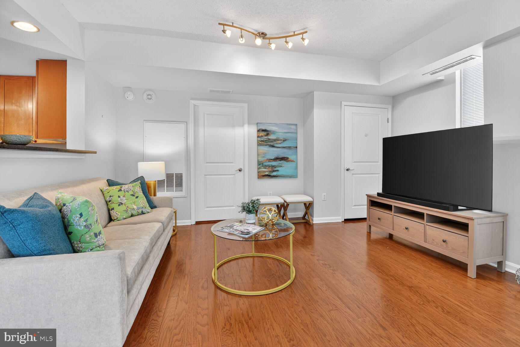 930 Wayne Avenue, Unit 405 Silver Spring, MD 20910 - Photo 7 of 37 a living room with furniture and a flat screen tv