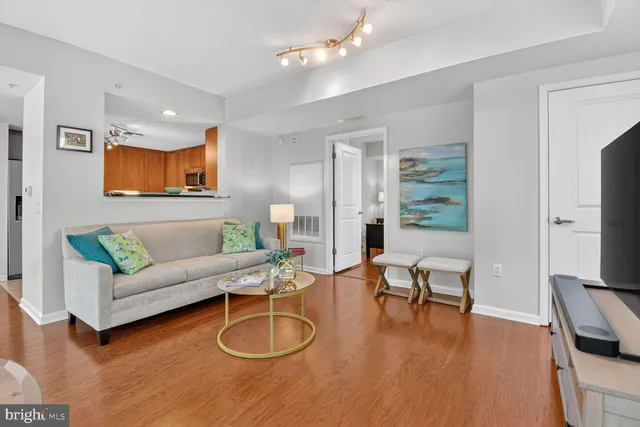 a living room with furniture a ceiling fan and a flat screen tv
