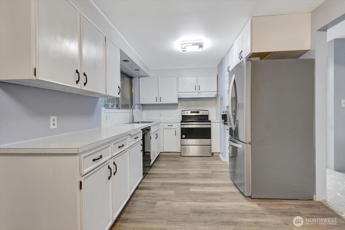 7313 228th Street Southwest Mountlake Terrace, WA 98043 - Photo 7 of 34 a kitchen with stainless steel appliances a refrigerator sink and cabinets