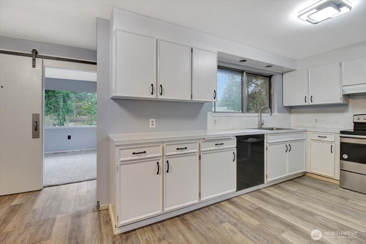 7313 228th Street Southwest Mountlake Terrace, WA 98043 - Photo 8 of 34 a kitchen with granite countertop white cabinets and white appliances