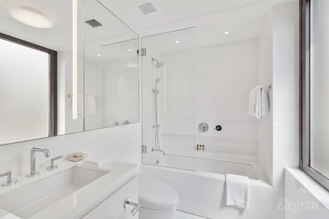a bathroom with a bathtub shower sink vanity and toilet