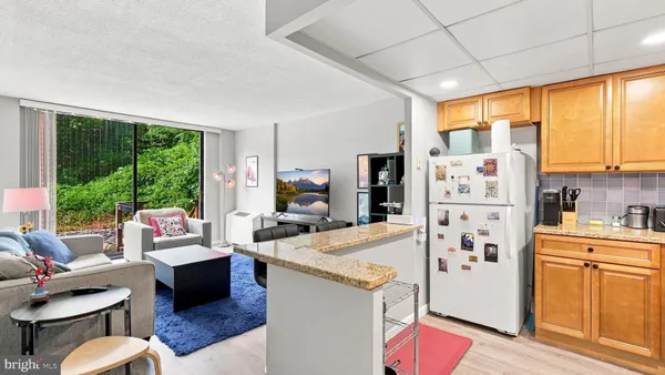 a living room with furniture a large window with kitchen view