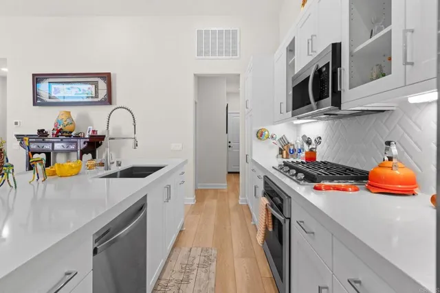 a kitchen with stainless steel appliances granite countertop a stove and a sink