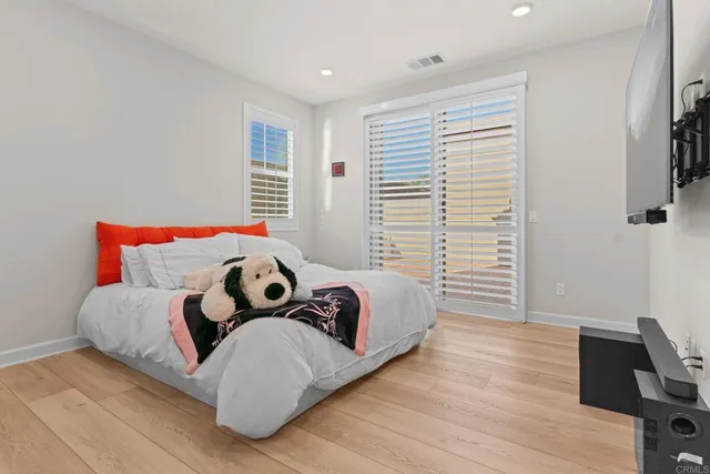 a bedroom with a bed and wooden floor