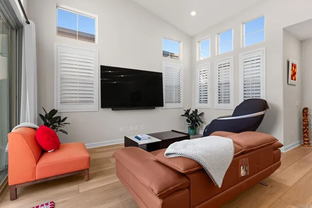 a living room with furniture a flat screen tv and a window