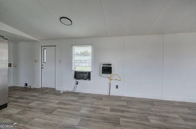 a view of a livingroom with wooden floor and a flat screen tv