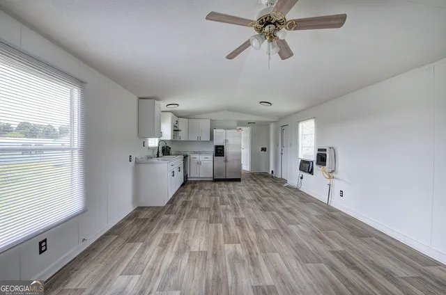 a view of a kitchen with wooden floor and a window