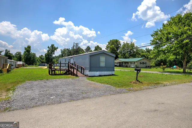 a view of a house with a big yard and a large tree