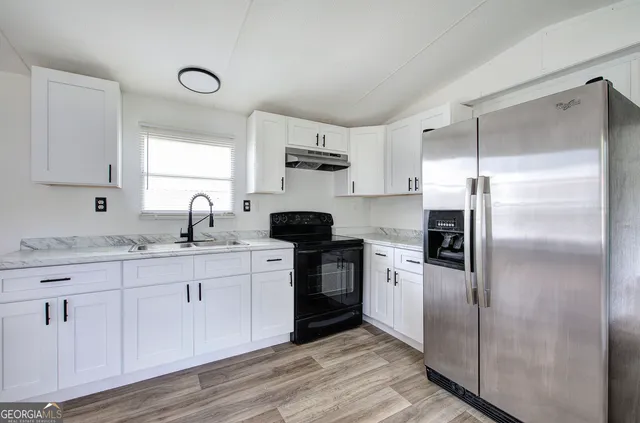 a kitchen with a refrigerator sink and cabinets