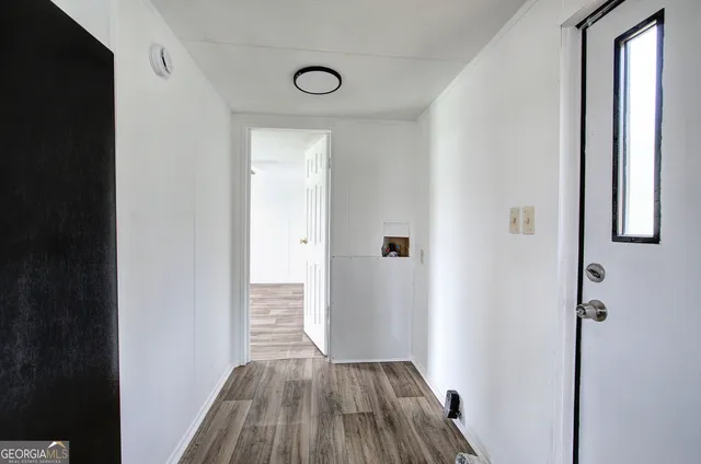 a view of a hallway with wooden floor