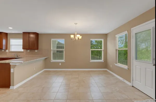 a large white kitchen with granite countertop a sink and dishwasher a stove with wooden floor